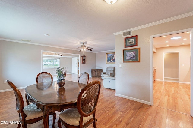 dining space featuring crown molding, a textured ceiling, ceiling fan, and light hardwood / wood-style flooring