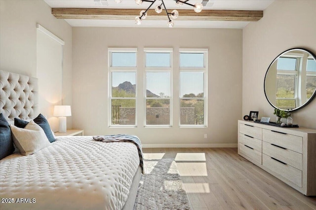 bedroom with light wood-type flooring, beam ceiling, and baseboards