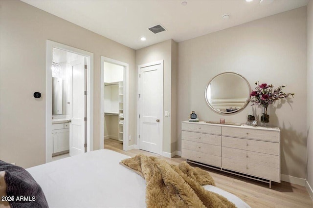 bedroom featuring baseboards, visible vents, ensuite bath, light wood-type flooring, and recessed lighting