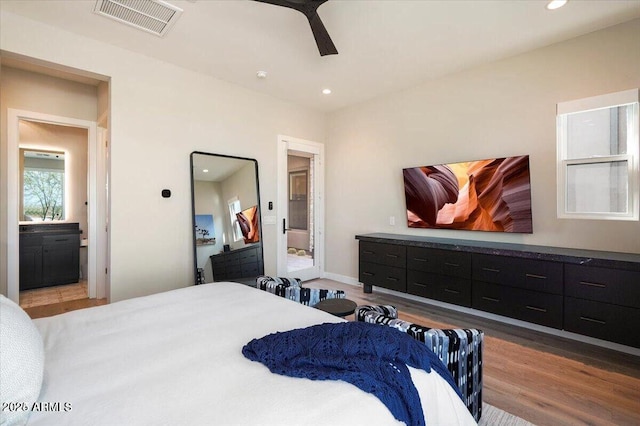 bedroom featuring ensuite bathroom, wood finished floors, visible vents, and recessed lighting