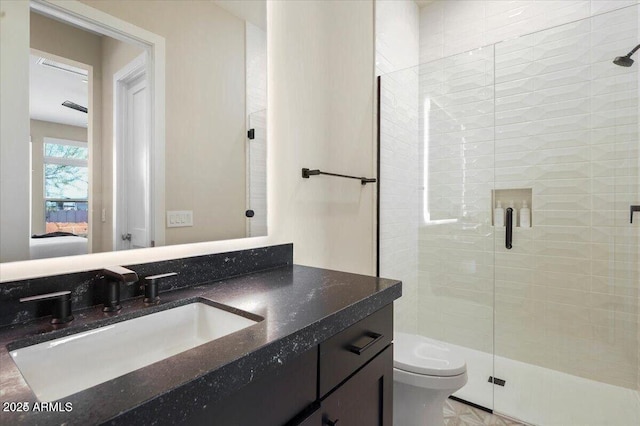 bathroom featuring a stall shower, vanity, toilet, and ensuite bathroom