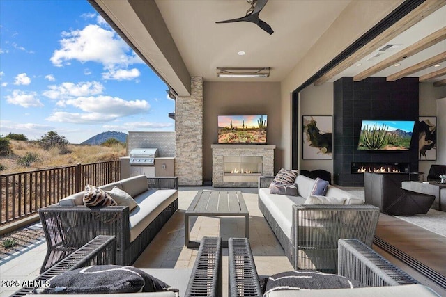 view of patio / terrace featuring a grill, ceiling fan, and an outdoor living space with a fireplace