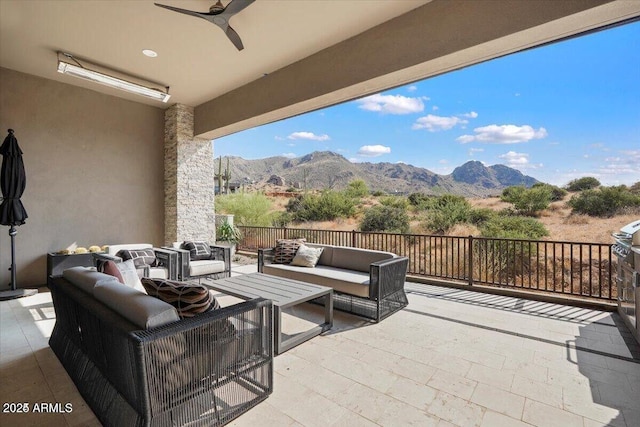 view of patio / terrace featuring a ceiling fan, a mountain view, and an outdoor hangout area