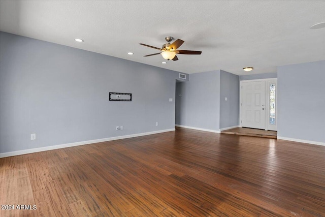 unfurnished room featuring dark wood-type flooring, ceiling fan, and a textured ceiling