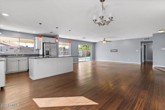 kitchen with plenty of natural light, dark hardwood / wood-style flooring, stainless steel fridge with ice dispenser, and a kitchen island