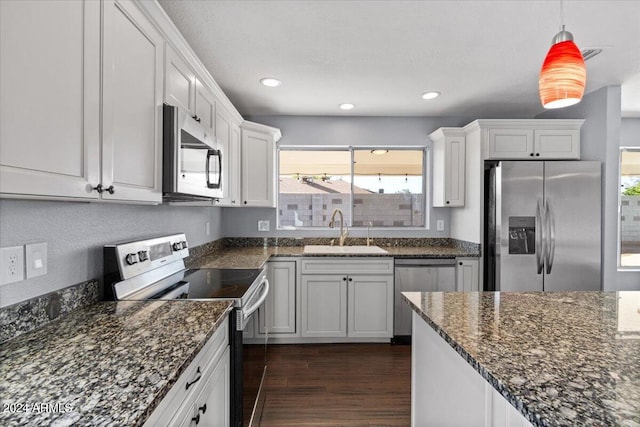 kitchen featuring appliances with stainless steel finishes, a healthy amount of sunlight, sink, and white cabinets