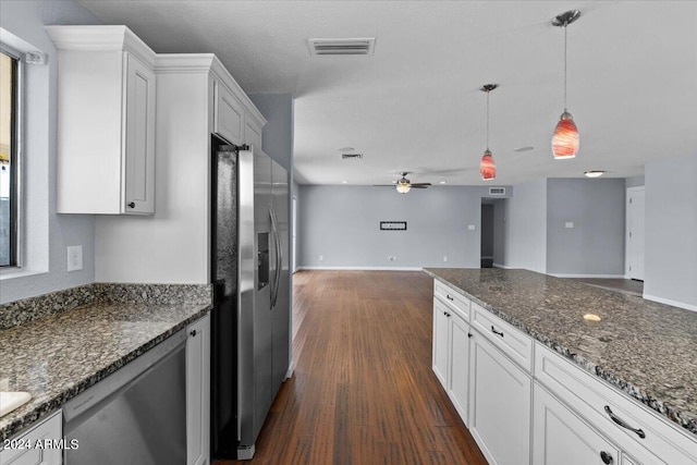 kitchen featuring hanging light fixtures, dark hardwood / wood-style floors, white cabinetry, and stainless steel appliances