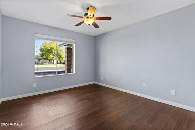 spare room featuring dark wood-type flooring and ceiling fan