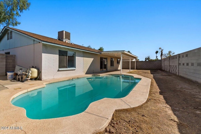 view of pool with cooling unit and a patio