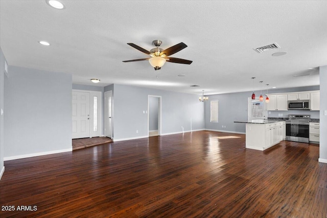 unfurnished living room featuring baseboards, a textured ceiling, ceiling fan with notable chandelier, and dark wood-style floors