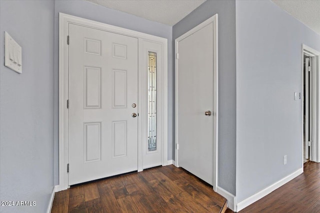 foyer featuring dark hardwood / wood-style floors and a textured ceiling