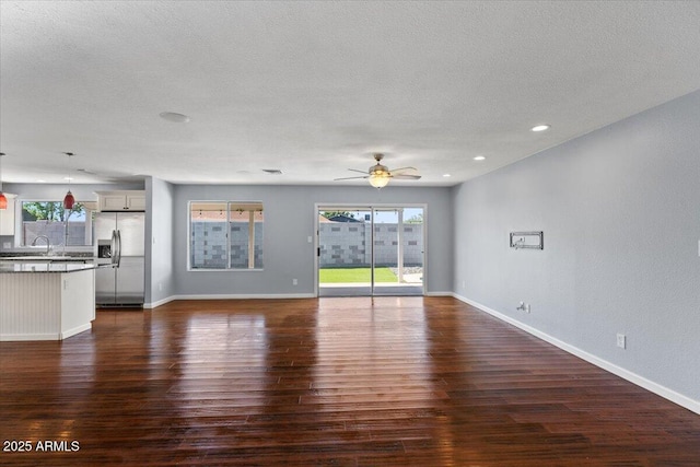 entryway with baseboards, dark wood-style floors, and a textured ceiling