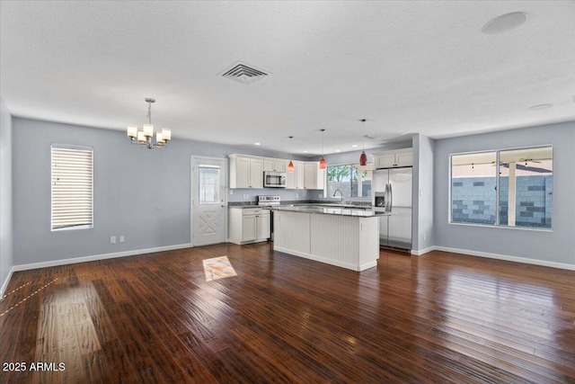 spare room with ceiling fan, a textured ceiling, visible vents, dark wood finished floors, and baseboards