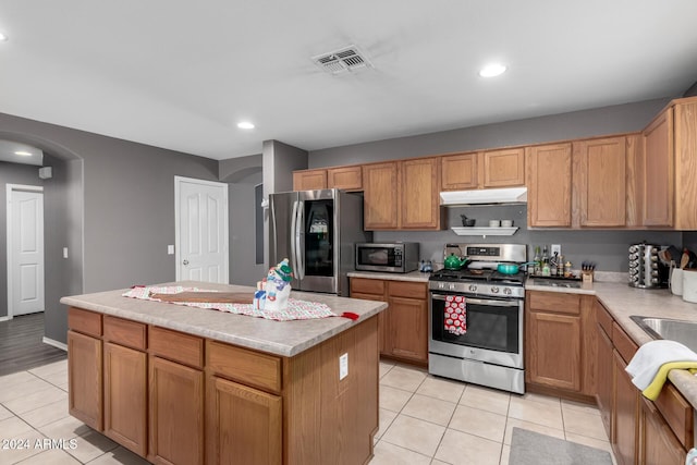 kitchen with a center island, light tile patterned floors, and stainless steel appliances