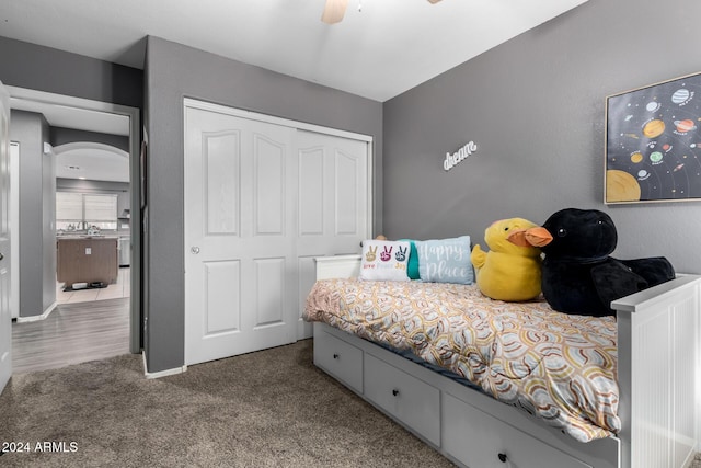 bedroom with carpet flooring, ceiling fan, a closet, and sink