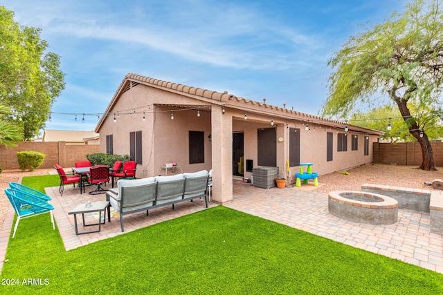 rear view of house with a lawn, a patio area, and an outdoor living space with a fire pit