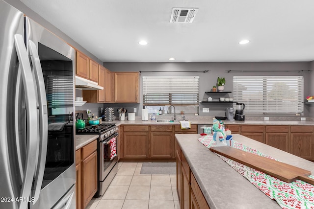 kitchen featuring appliances with stainless steel finishes, light tile patterned floors, and sink