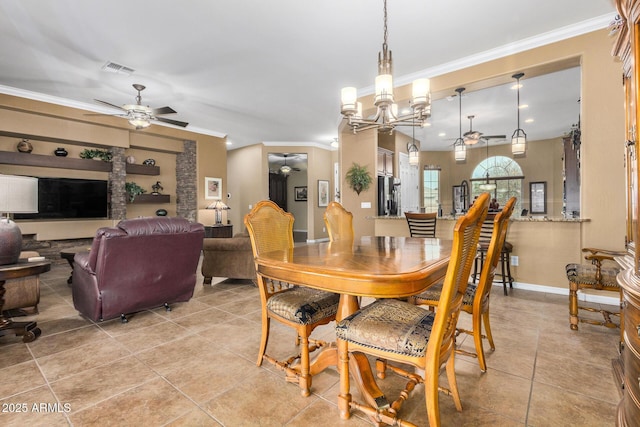 tiled dining room featuring ceiling fan with notable chandelier and ornamental molding