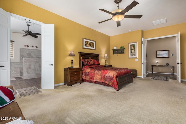 bedroom with light carpet, ceiling fan, and connected bathroom