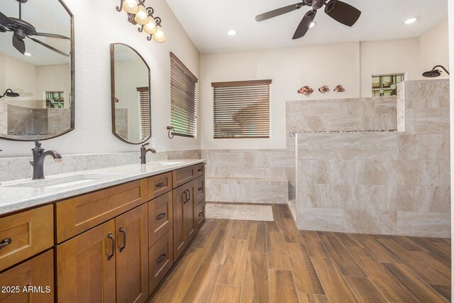 bathroom featuring ceiling fan, vanity, and walk in shower