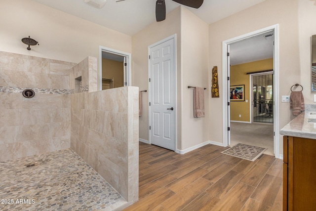 bathroom featuring ceiling fan, walk in shower, and vanity