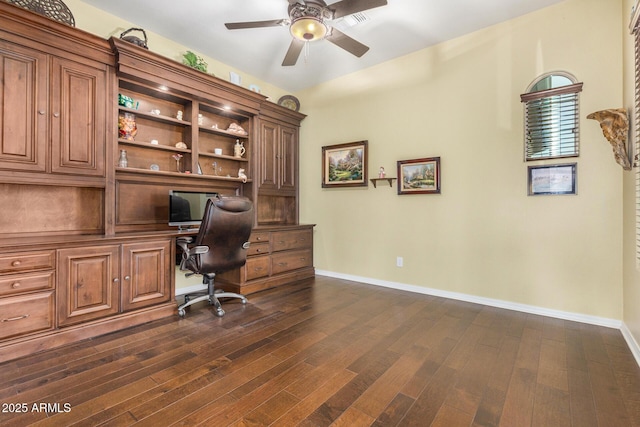 office area with ceiling fan, dark hardwood / wood-style flooring, and built in desk