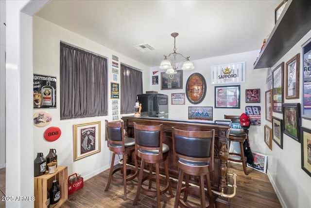 bar with baseboards, a dry bar, visible vents, and wood finished floors