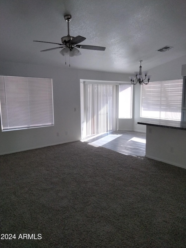 unfurnished room with carpet flooring, lofted ceiling, a textured ceiling, and ceiling fan with notable chandelier