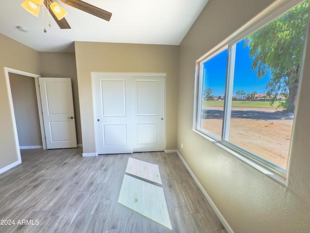 unfurnished bedroom with ceiling fan, a closet, and light wood-type flooring