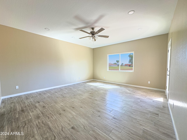 empty room featuring ceiling fan and light hardwood / wood-style floors