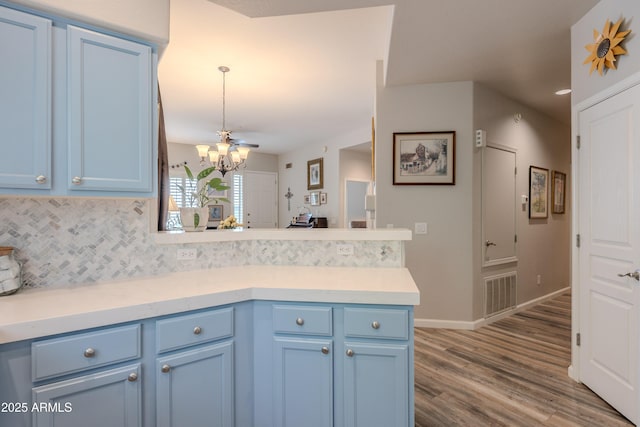 8180 E Shea Blvd Unit 1043, Scottsdale, AZ 85260 - kitchen featuring blue cabinets, a peninsula, a chandelier, backsplash, and recessed lighting