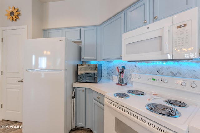 8180 E Shea Blvd Unit 1043, Scottsdale, AZ 85260 - kitchen with white appliances, tasteful backsplash, light countertops, blue cabinetry, and light wood finished floors