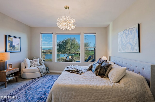 carpeted bedroom featuring a chandelier and baseboards