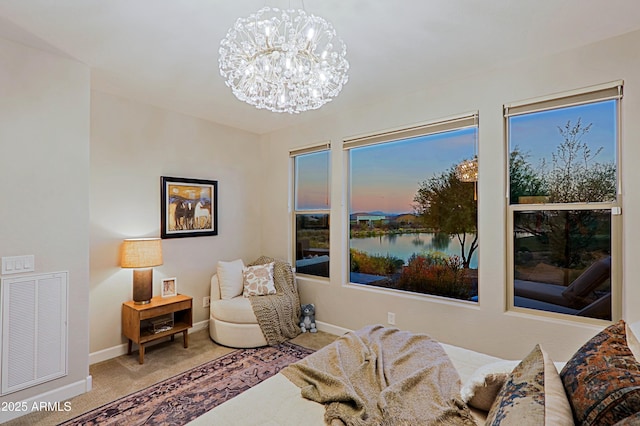 sitting room with carpet, a notable chandelier, visible vents, a water view, and baseboards