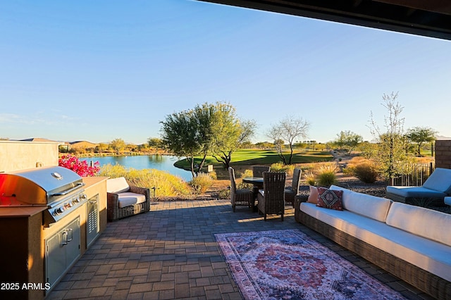 view of patio / terrace with a water view, a grill, an outdoor living space, and area for grilling