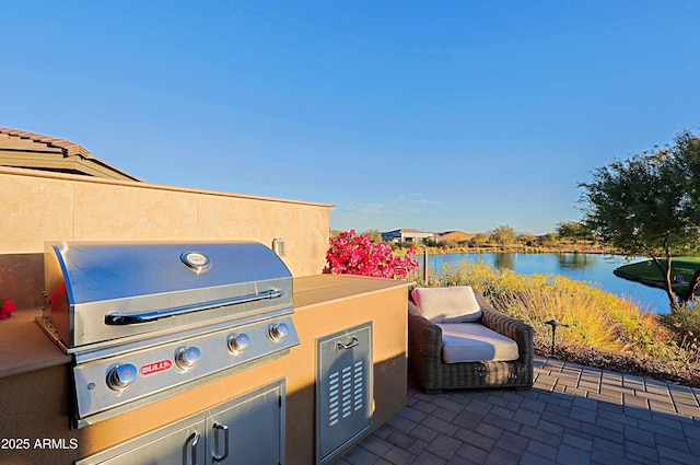 view of patio with a water view and a grill