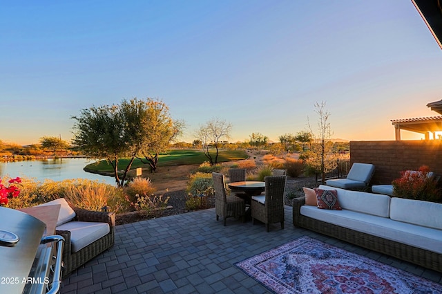 patio terrace at dusk with a water view, an outdoor living space, and outdoor dining space