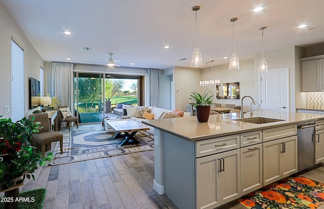 kitchen with open floor plan, light countertops, a sink, and visible vents