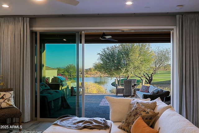 doorway featuring a water view, a ceiling fan, wood finished floors, and recessed lighting