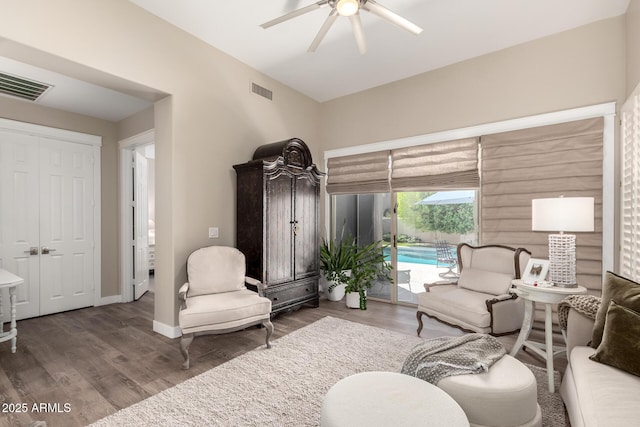 living room with visible vents, a ceiling fan, baseboards, and wood finished floors