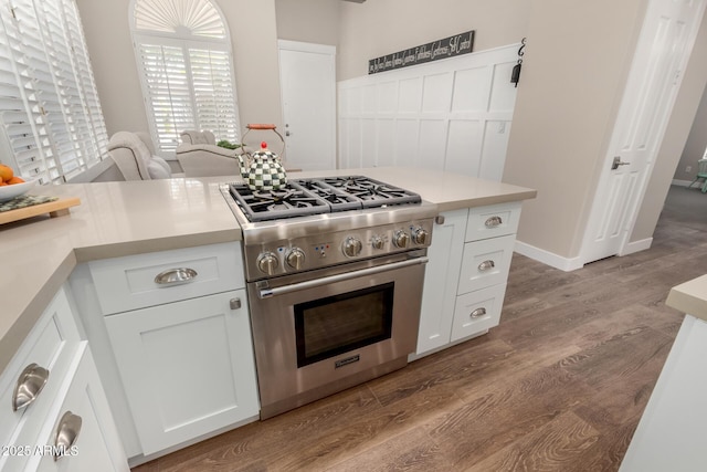 kitchen with light countertops, high end stainless steel range, and wood finished floors
