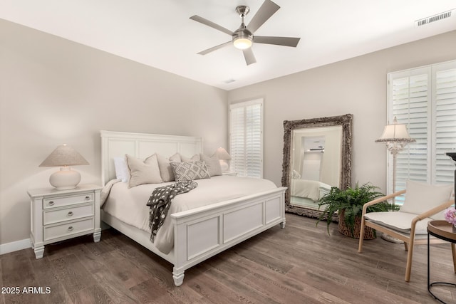 bedroom featuring visible vents, baseboards, ceiling fan, and dark wood-style floors