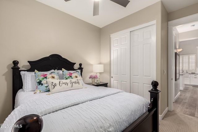 bedroom with baseboards, light colored carpet, ceiling fan, and a closet