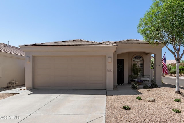 view of front of home featuring a garage, stucco siding, a tiled roof, and concrete driveway
