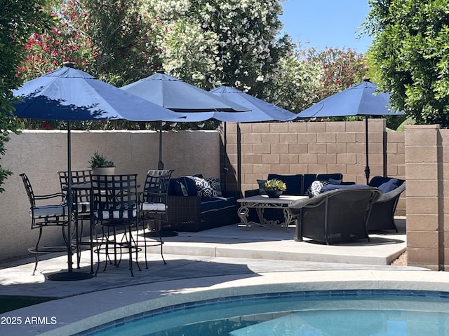 view of pool with a fenced in pool, outdoor lounge area, a patio area, and fence