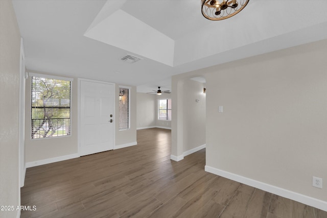 entrance foyer featuring hardwood / wood-style floors, ceiling fan with notable chandelier, and a wealth of natural light