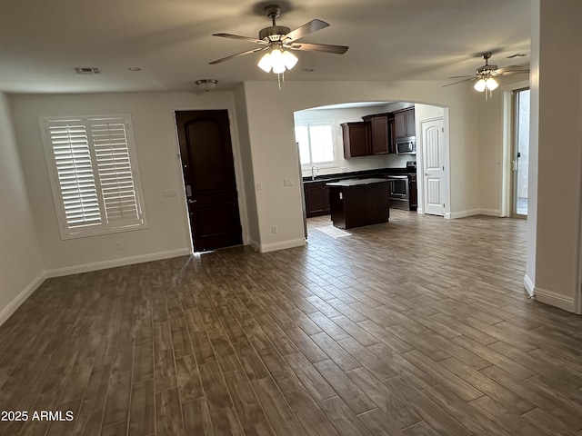 unfurnished living room featuring ceiling fan, dark hardwood / wood-style floors, and sink