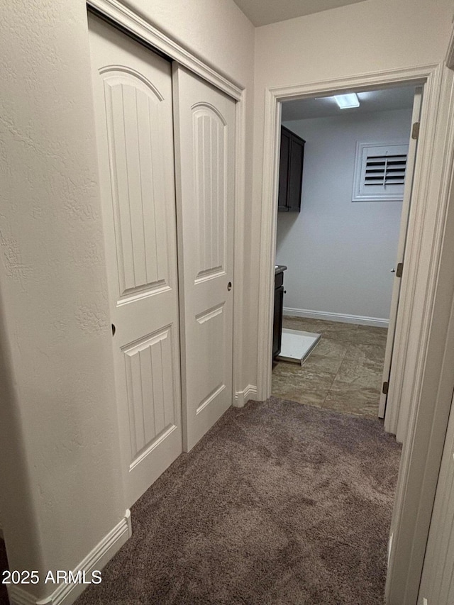 hallway featuring dark colored carpet