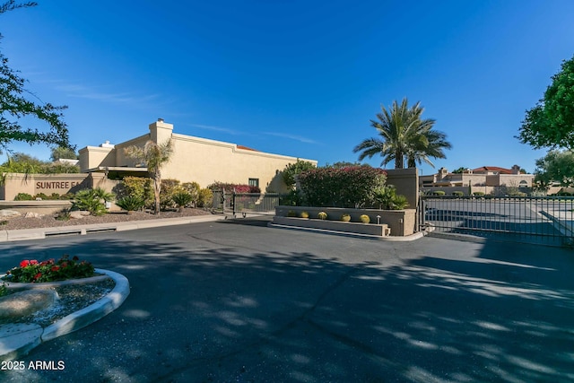 view of street featuring a gate, a gated entry, and curbs