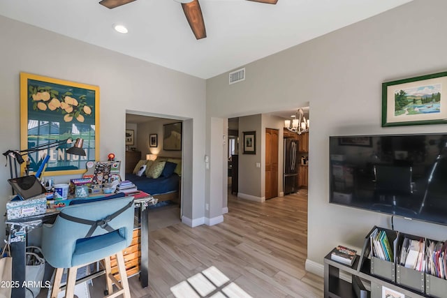 interior space featuring visible vents, light wood-style flooring, baseboards, and ceiling fan with notable chandelier